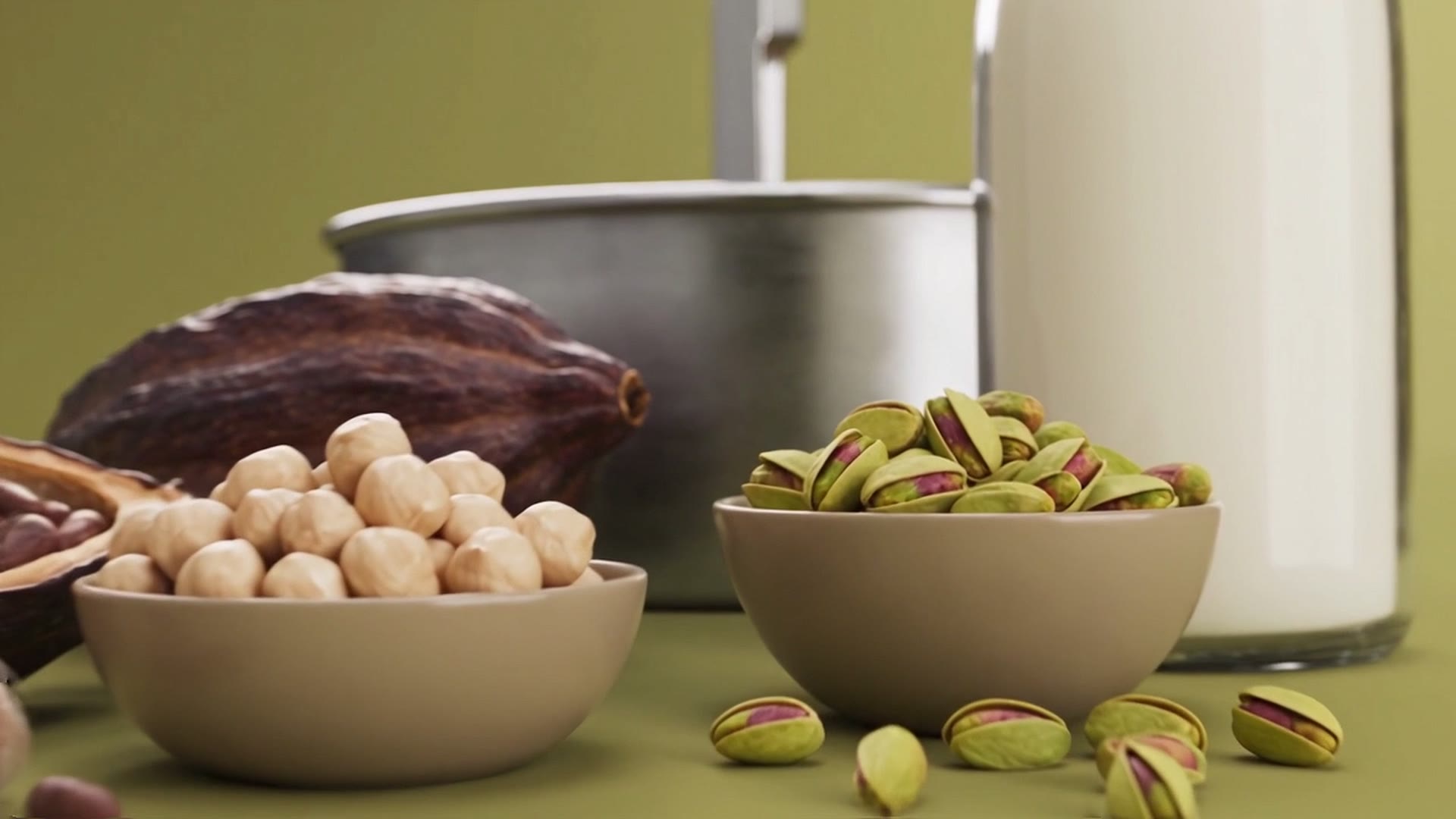 Latte, un baccello di cacao aperto, nocciole e pistacchi davanti alla pentola