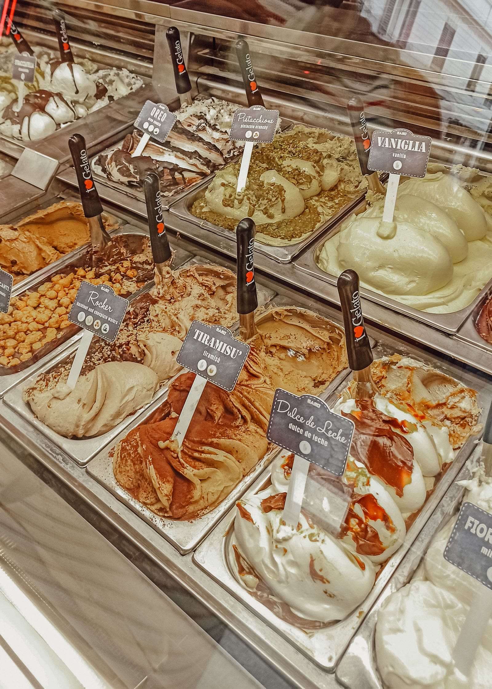 Il banco di una gelateria con le vaschette in fila