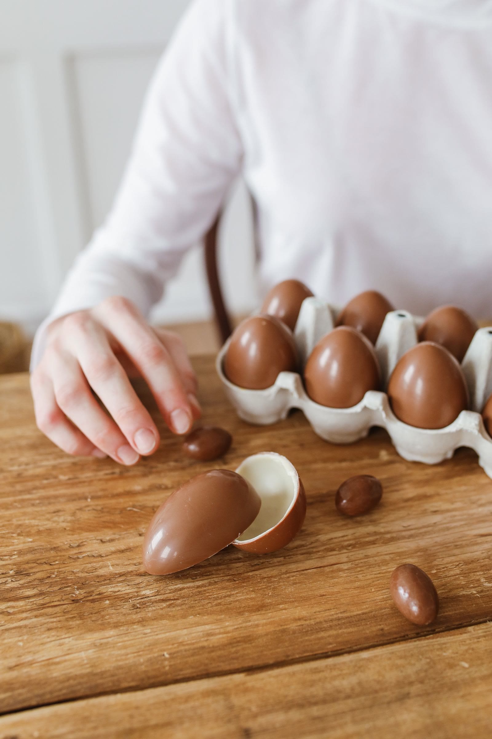 Una mano che prende un uovo di cioccolato da una scatola