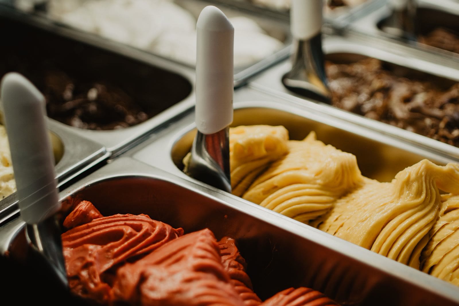Vaschette di gelato di gusti diversi in un banco